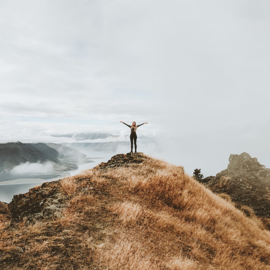 girl standing on top of a hill