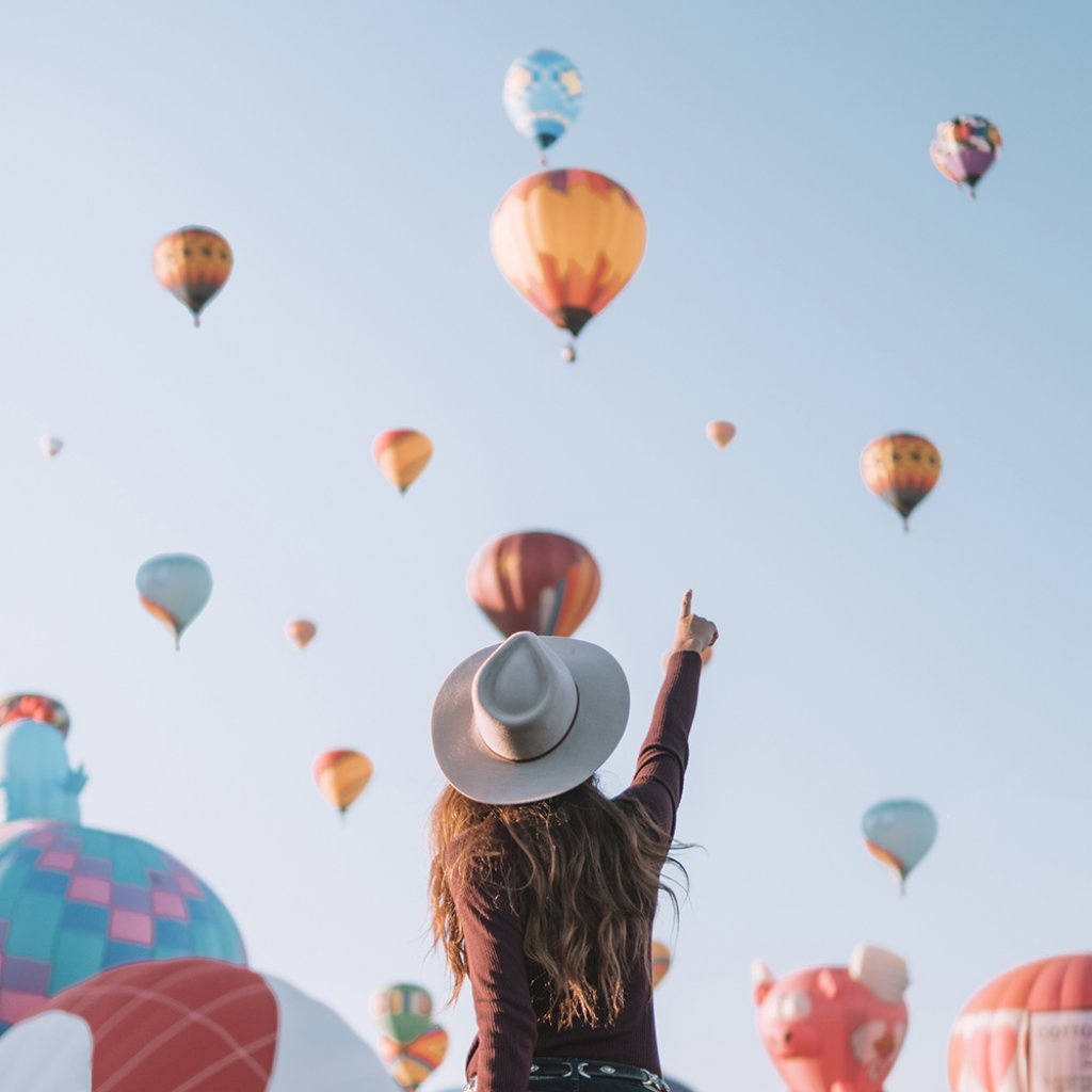 girl pointing at hot air balloons