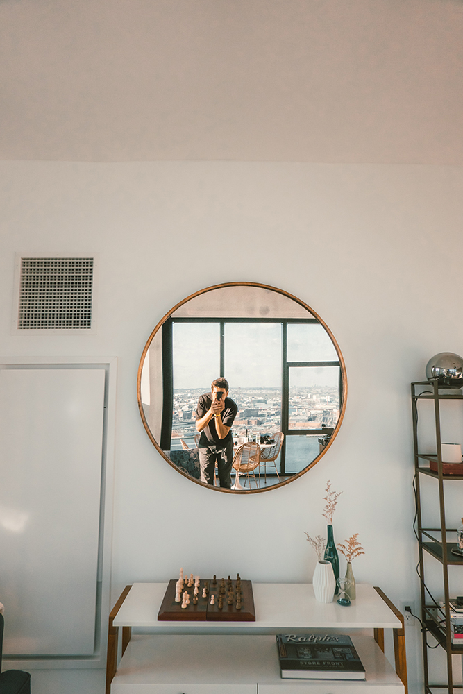 boy taking mirror selfie in a large room