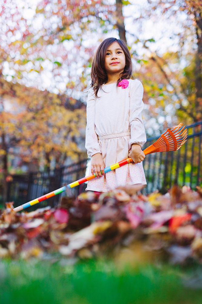 little girl holding rake and posing