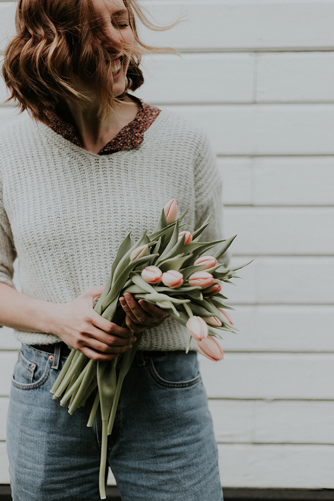 girl laughing and holding flowers